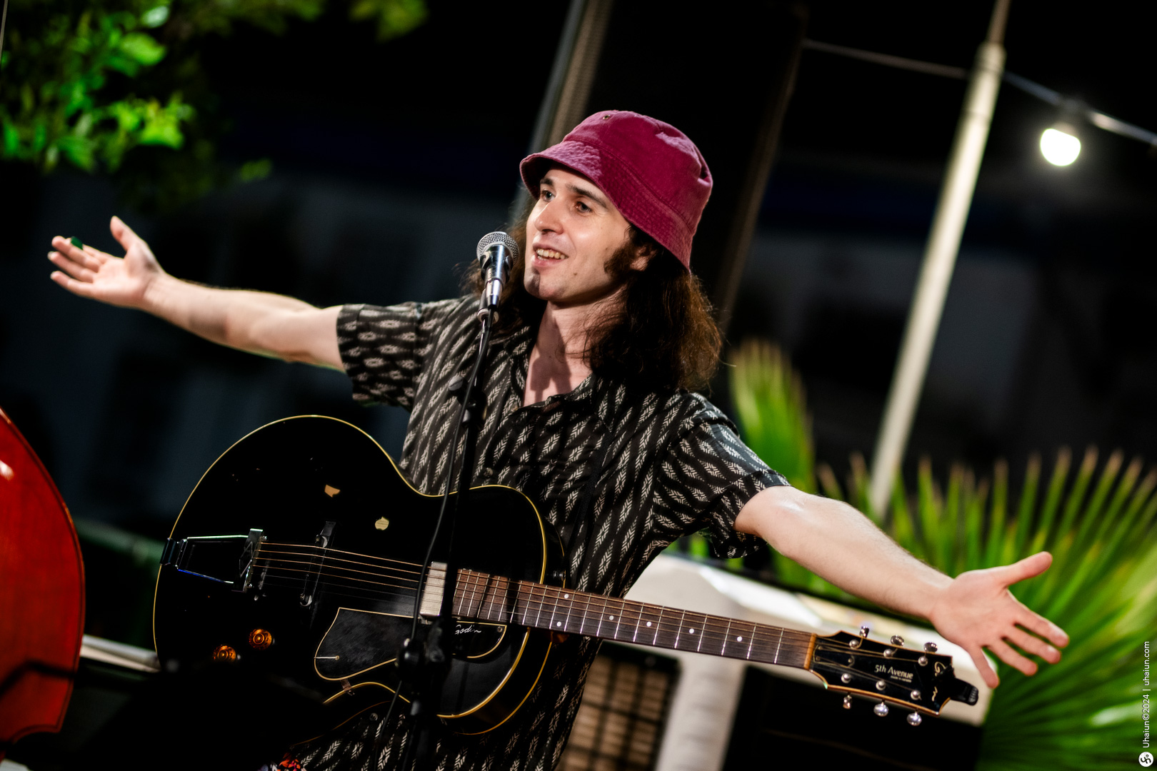 Musician with guitar performing on stage outdoors