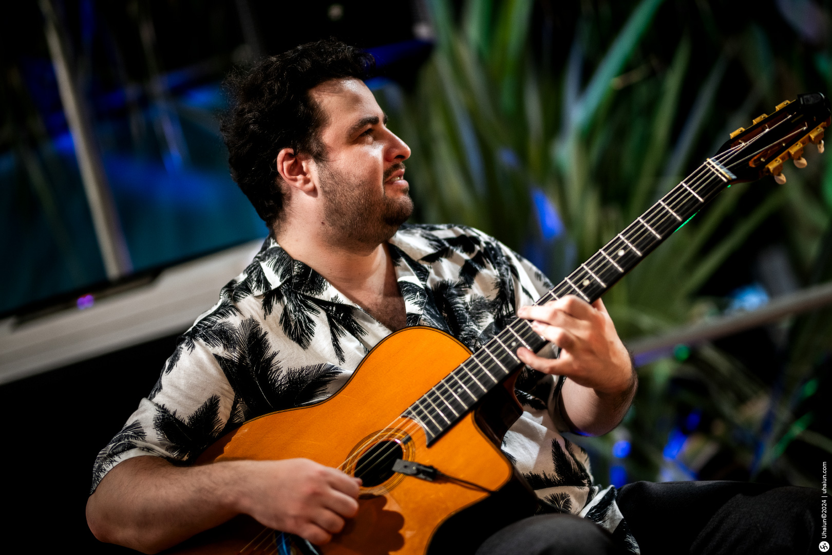Man playing an acoustic guitar at an event