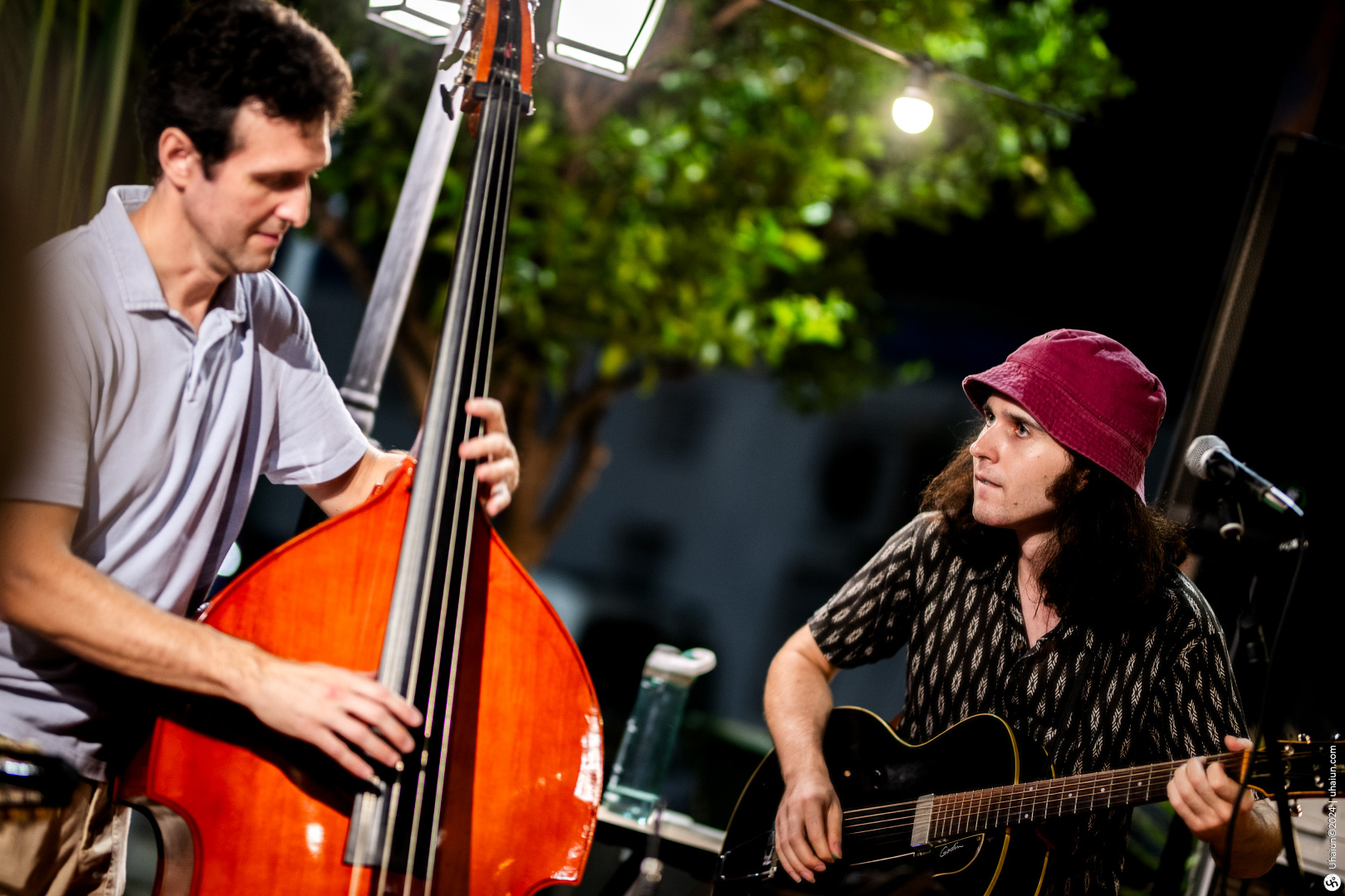 Two musicians playing double bass and guitar onstage