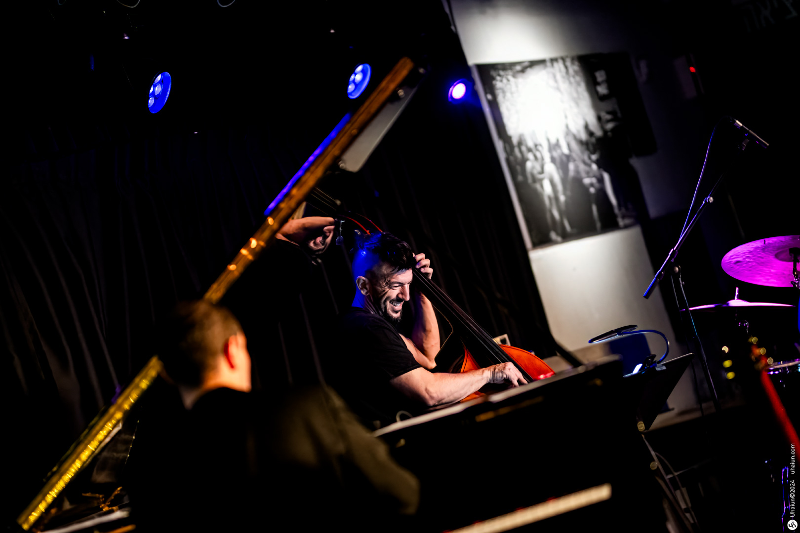 Musician playing double bass on stage with lights