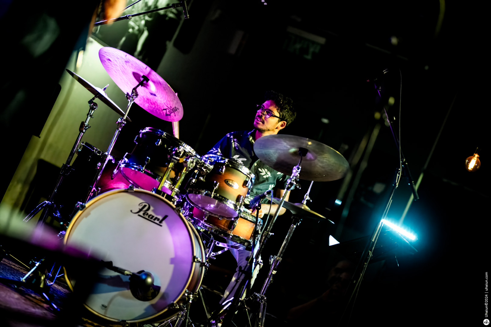 Drummer performing on stage with drum kit