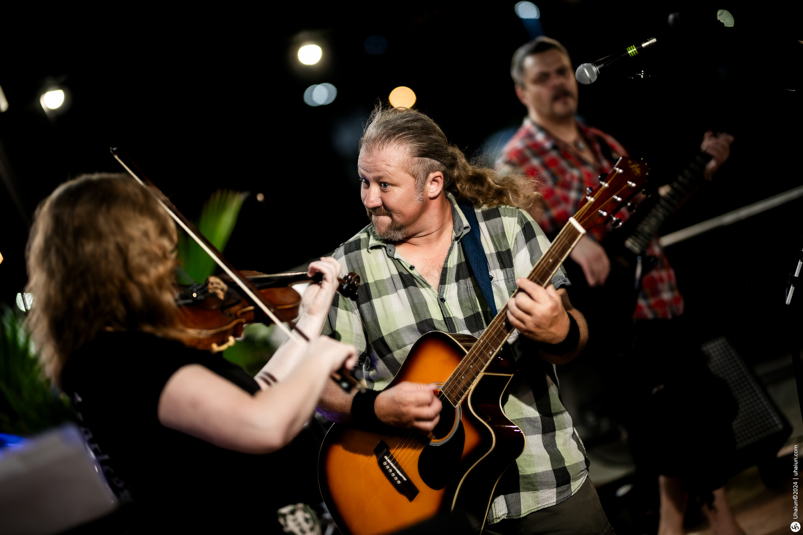 Live band musicians playing guitar and violin