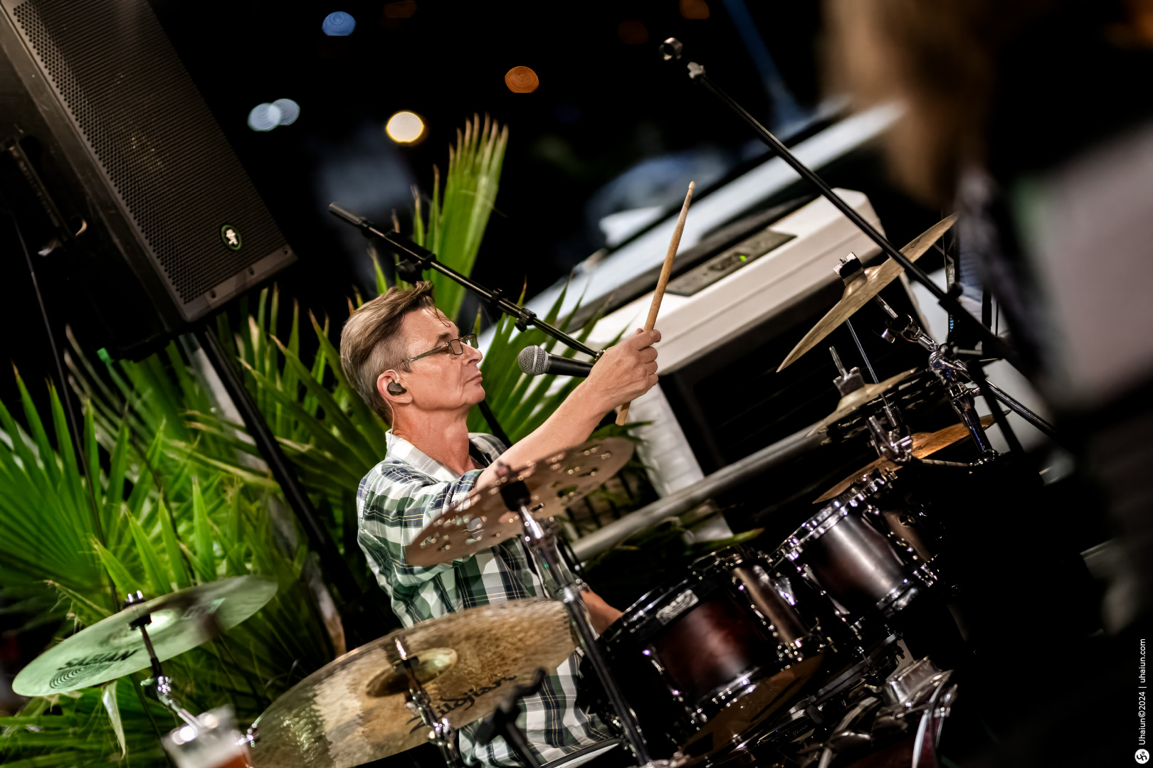 Drummer playing at a live music event at night