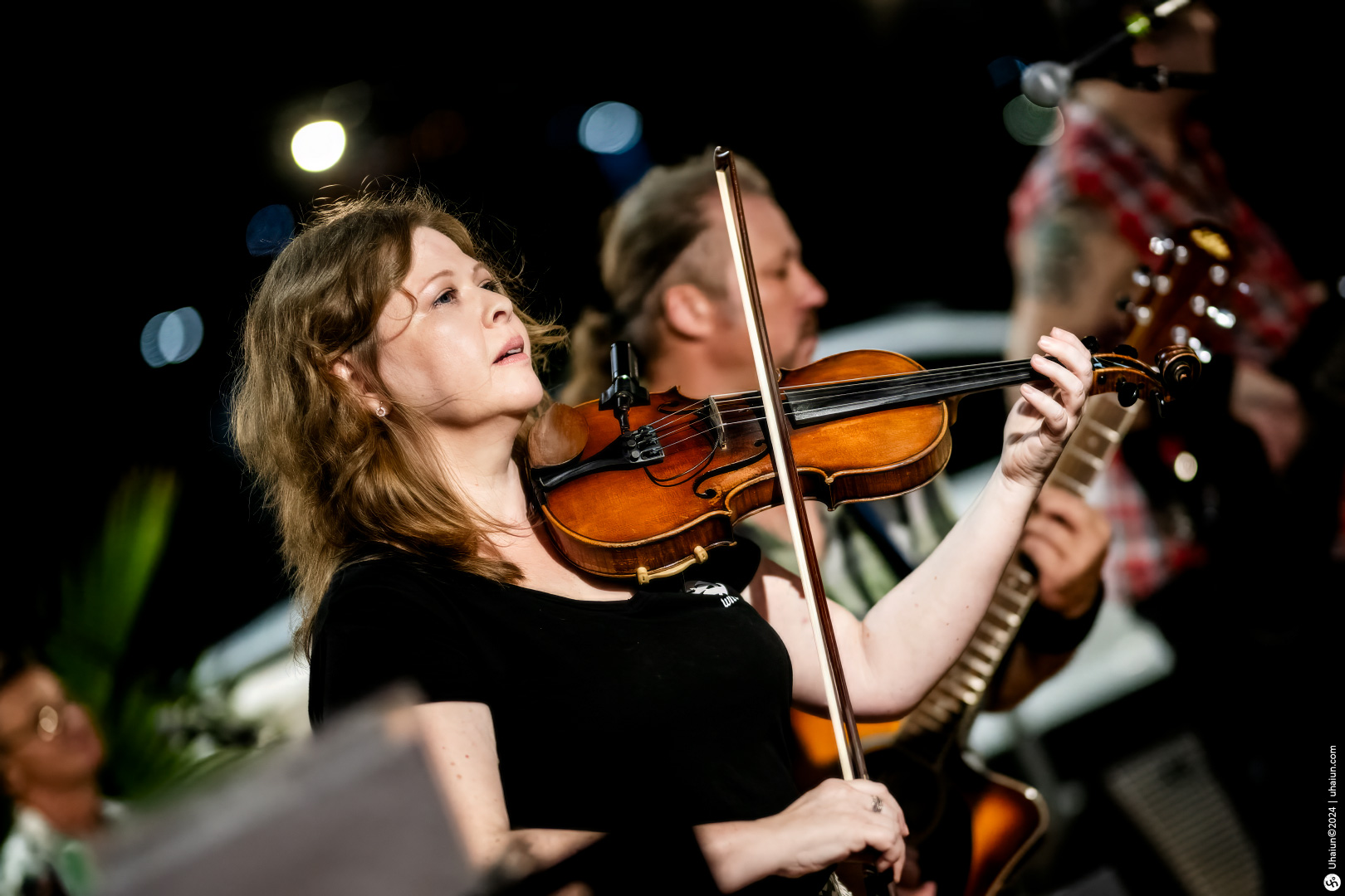 Woman playing violin in live music concert