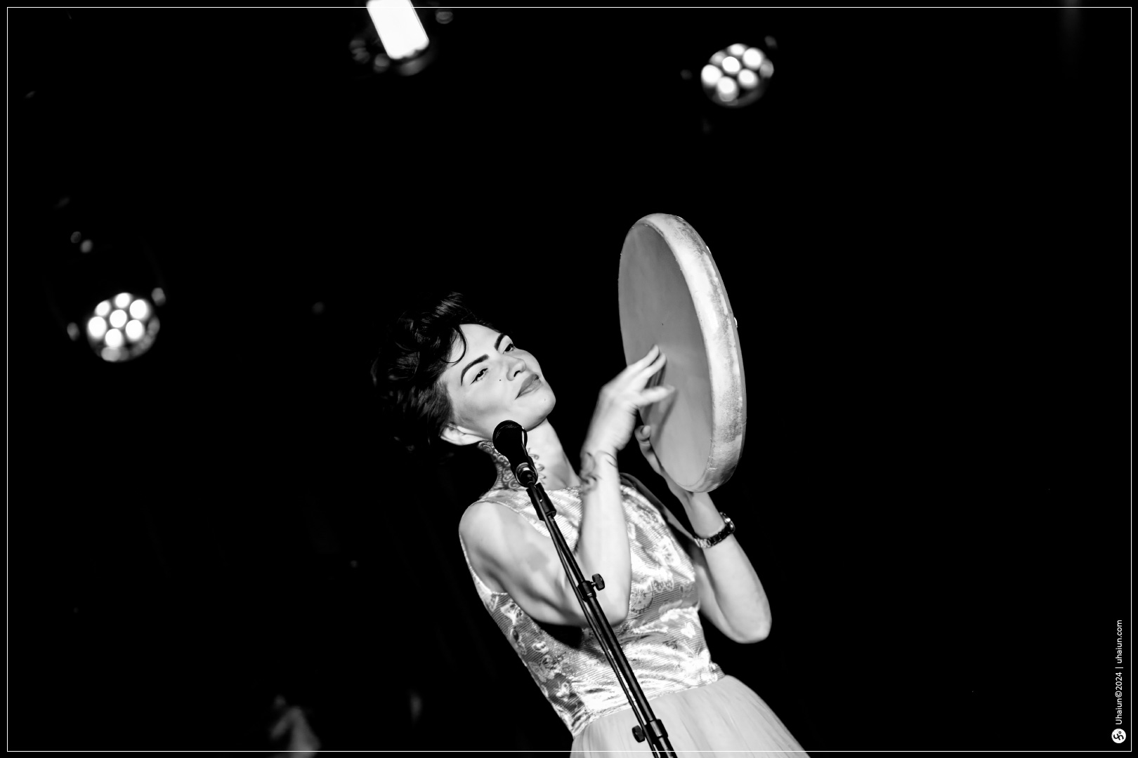 Kama Kamila performing with tambourine on stage