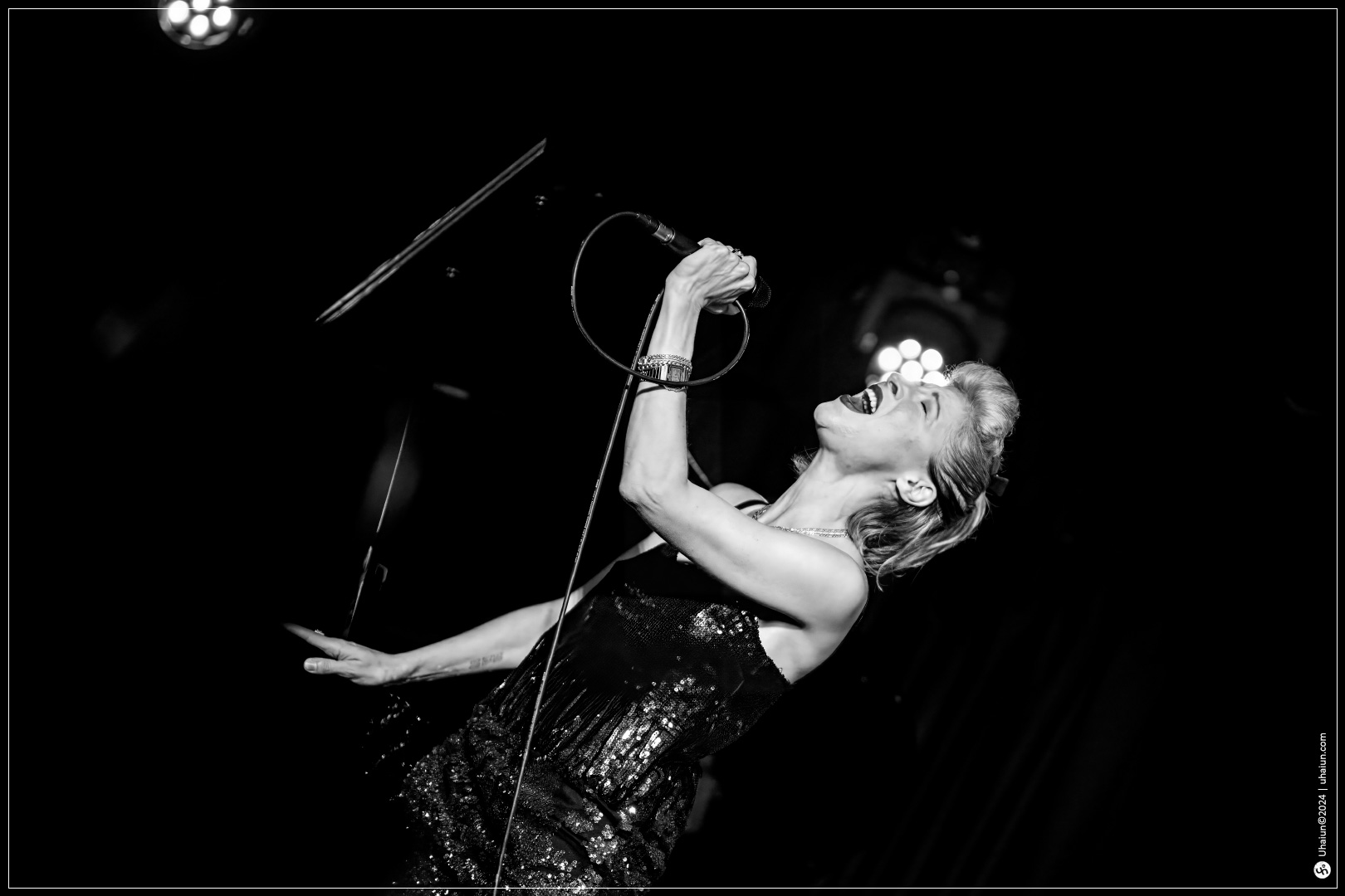 Michal Shapira singing passionately on stage in black and white