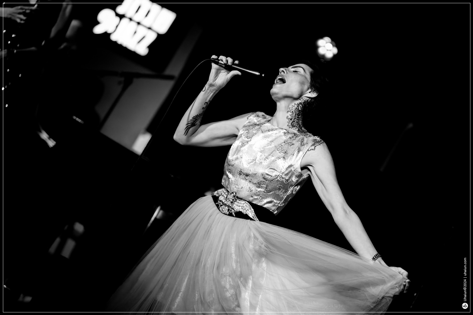 Kama Kamila singing passionately on stage in concert