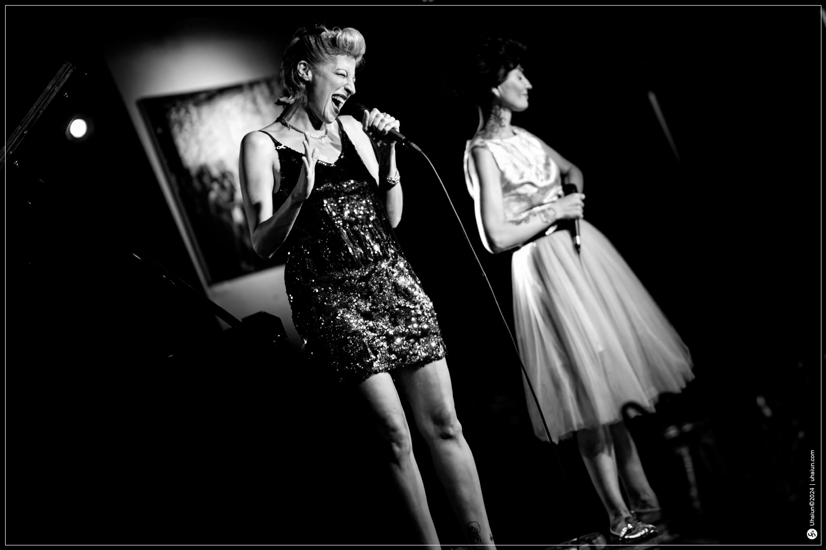 Kama Kamila singing on stage with Michal Shapira standing.