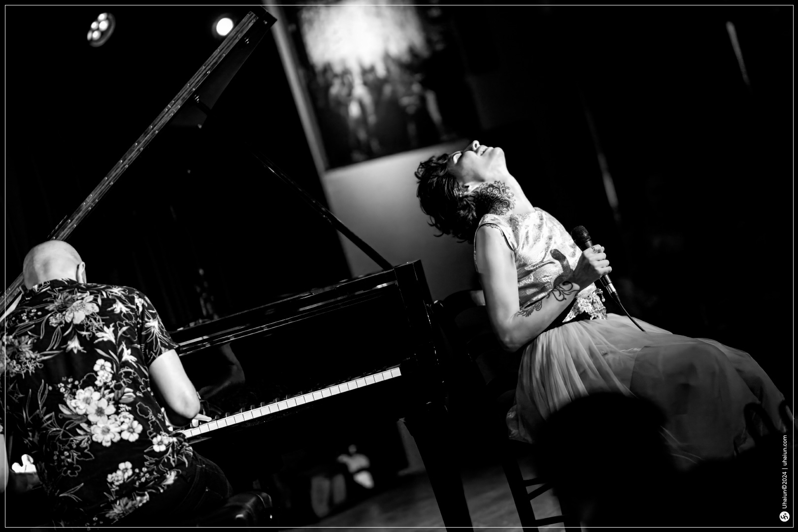 Kama Kamila singing passionately with pianist onstage