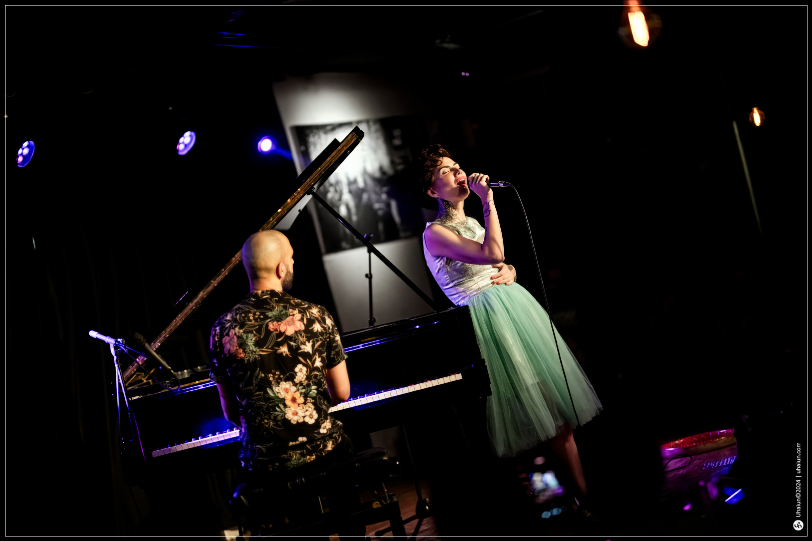 Kama Kamila singing on stage with pianist