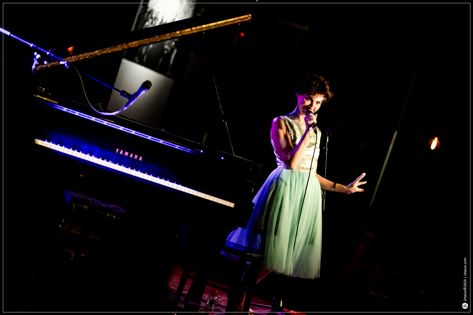 Kama Kamila performing live on stage with microphone