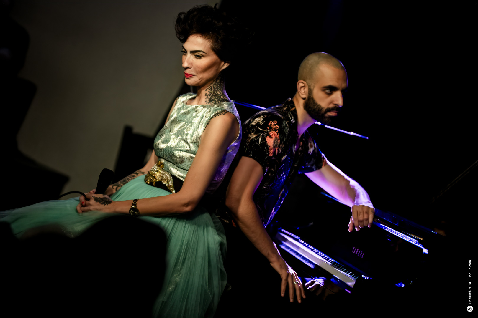 Kama Kamila duo performing on a dimly lit stage