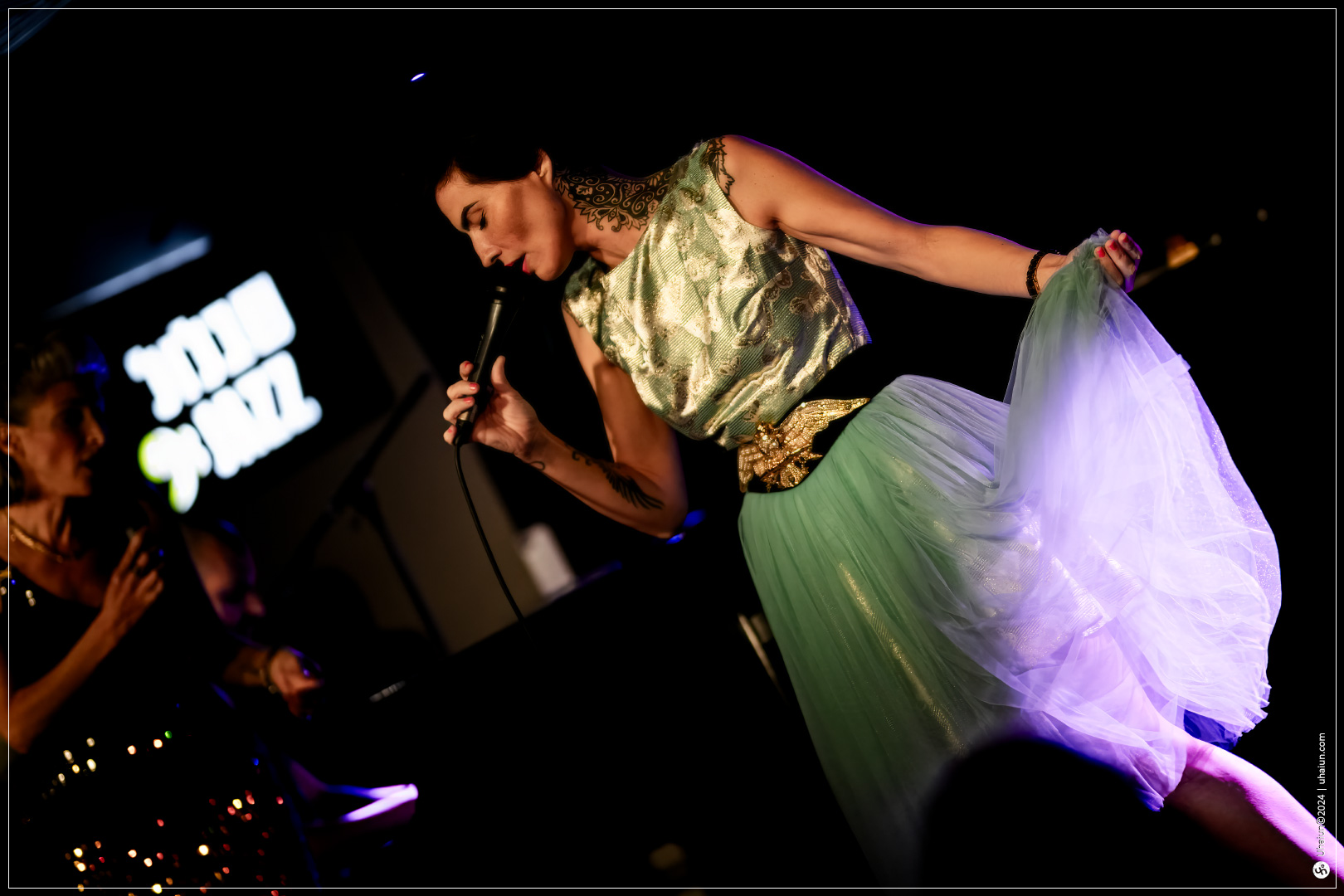 Kama Kamila performing live on stage with microphone