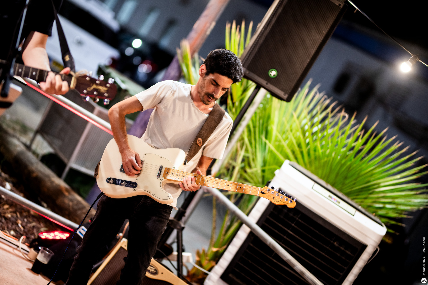 Guitar player performing live at an outdoor event.