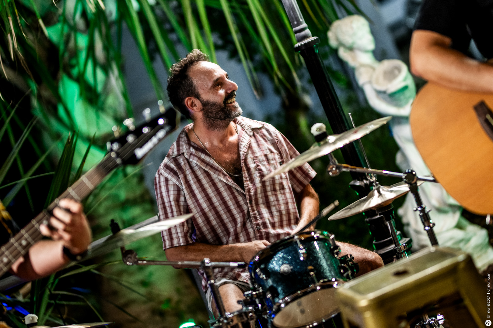 Drummer playing at a live music event outdoors.