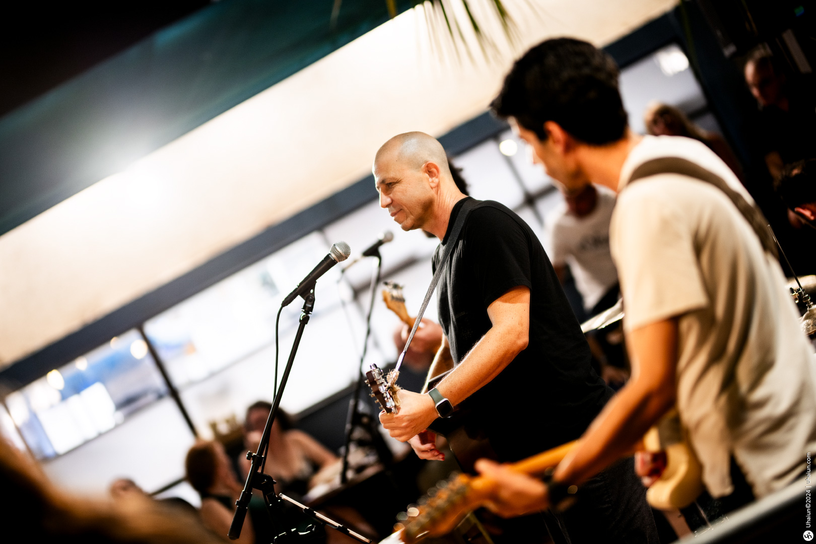 Band performing live on stage with guitars