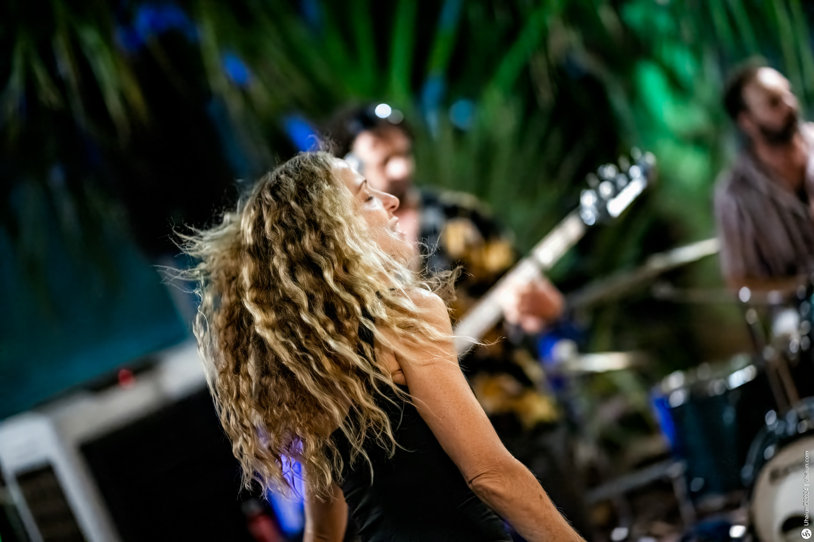 Female performing live with guitarist in background