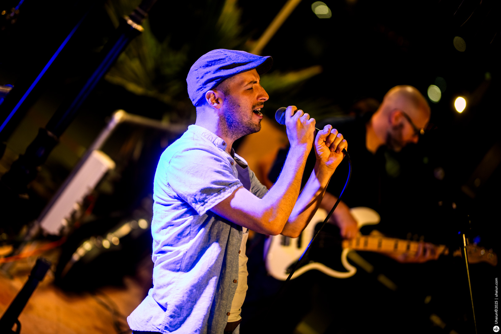 Man singing passionately on stage with band