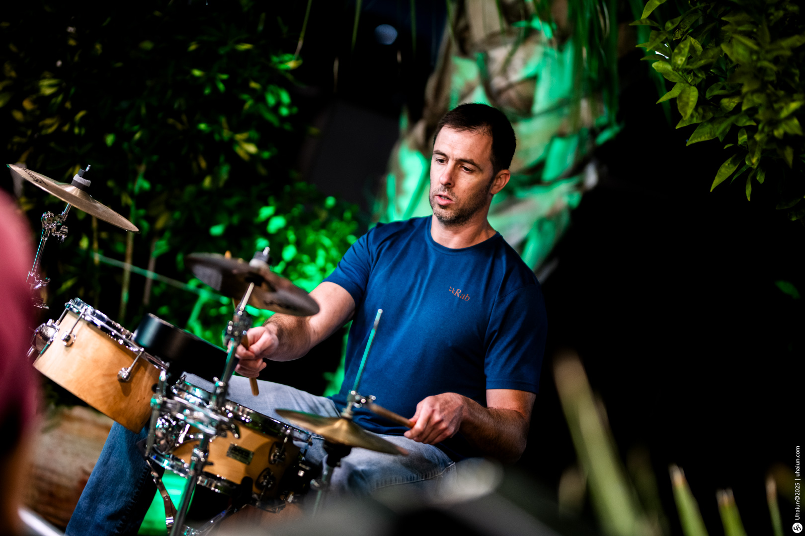Man playing drums in outdoor garden setting