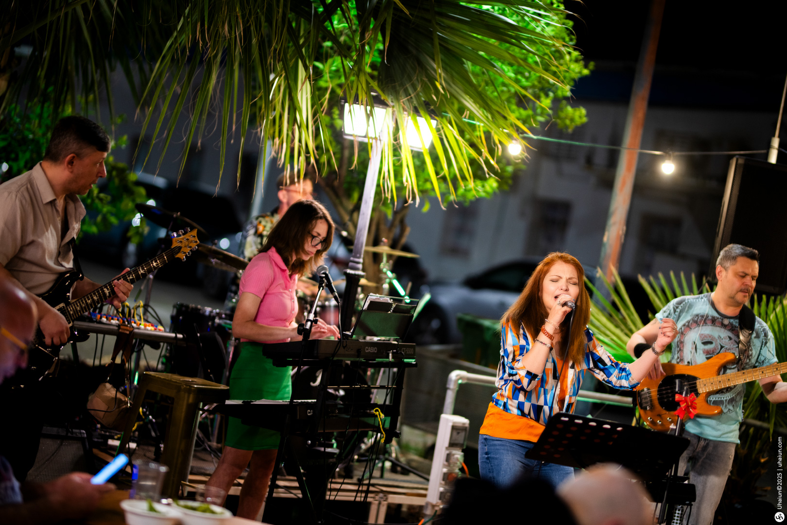 Live outdoor band performance under palm trees