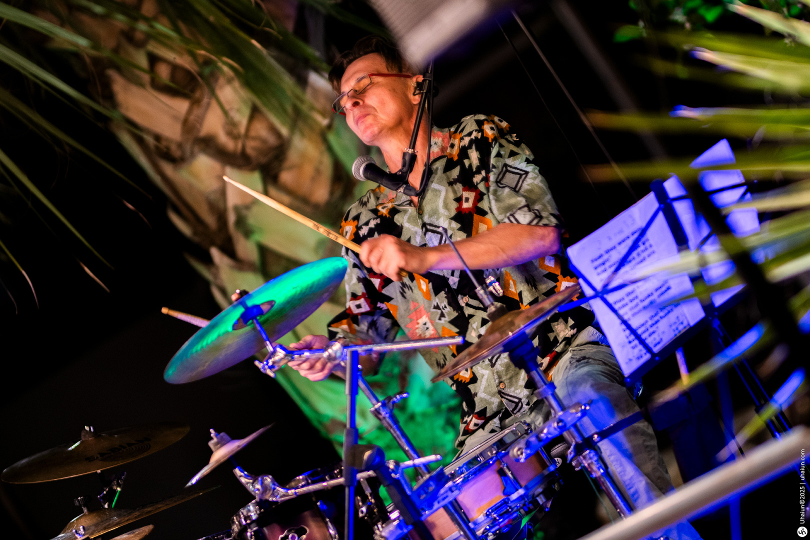 Drummer performing passionately at live music event