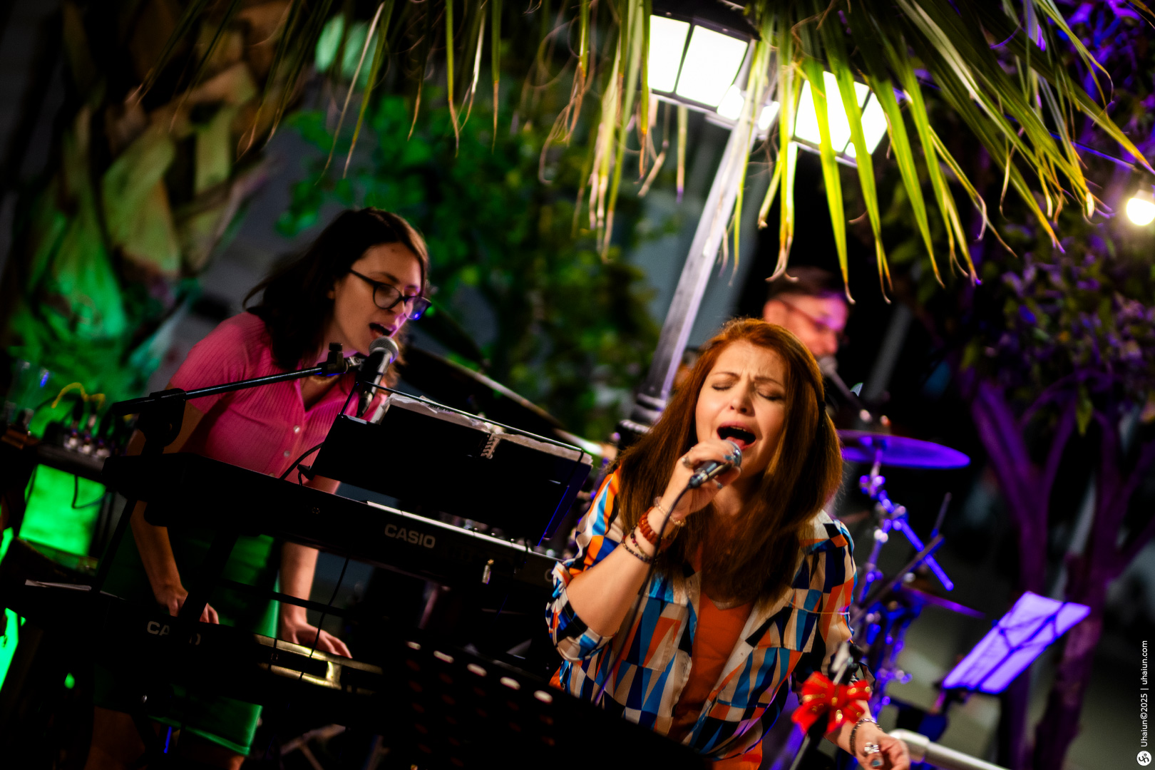 Singers performing live on stage with instruments