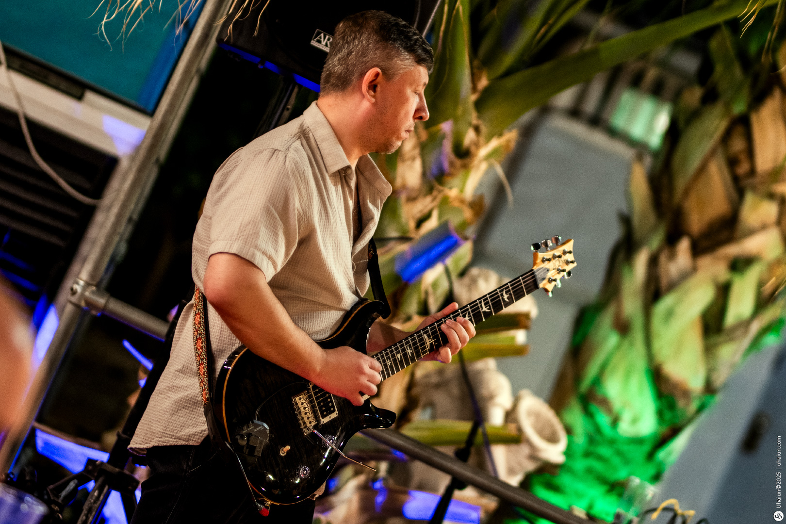 Guitarist performing at outdoor music event stage