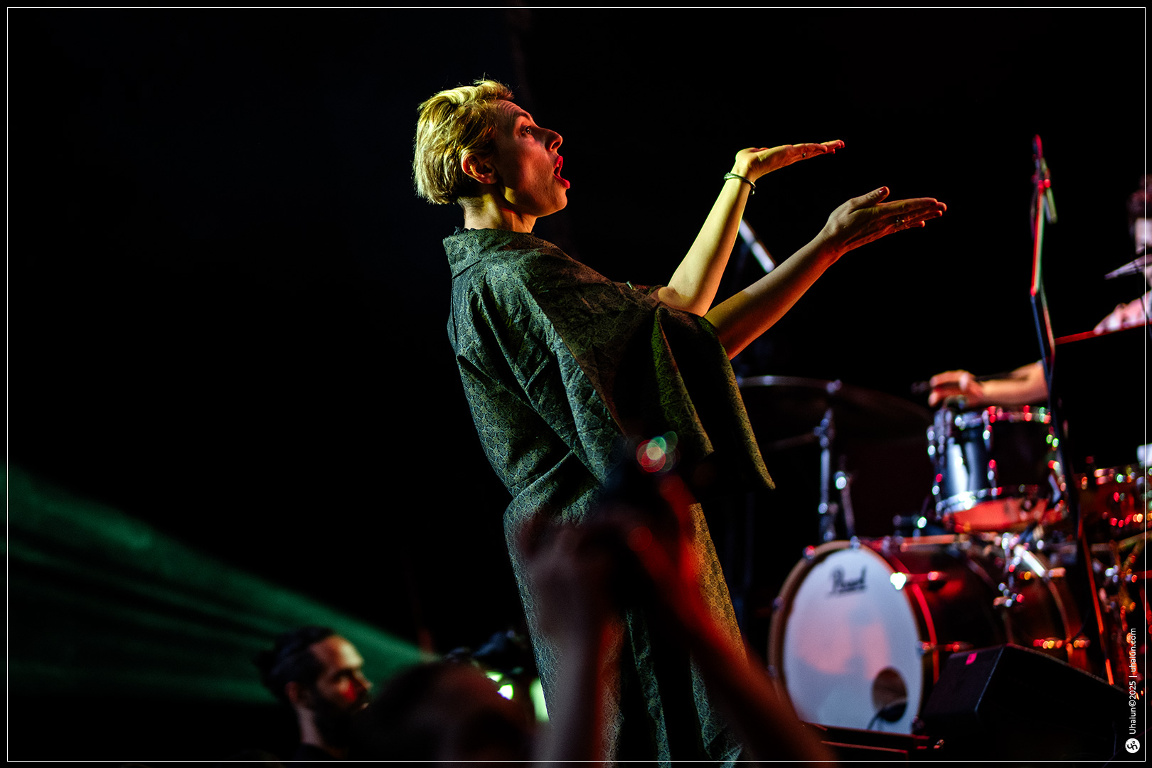 Performer on stage with drum set background