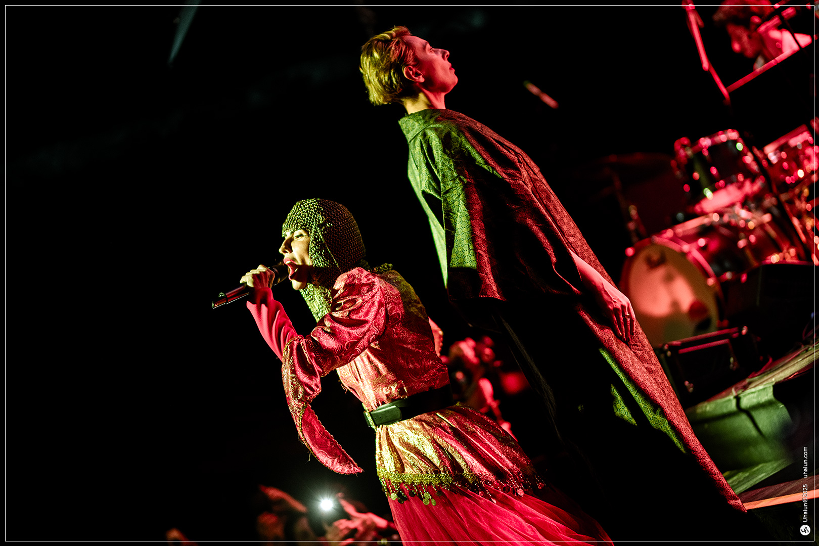 Two performers singing on stage with microphones