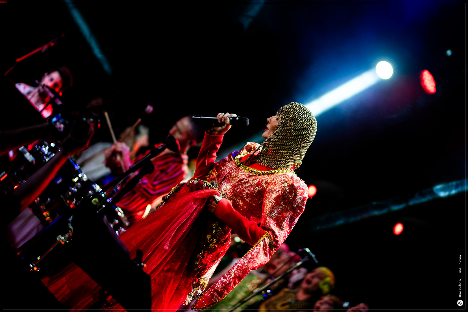Performer in colorful costume singing on stage