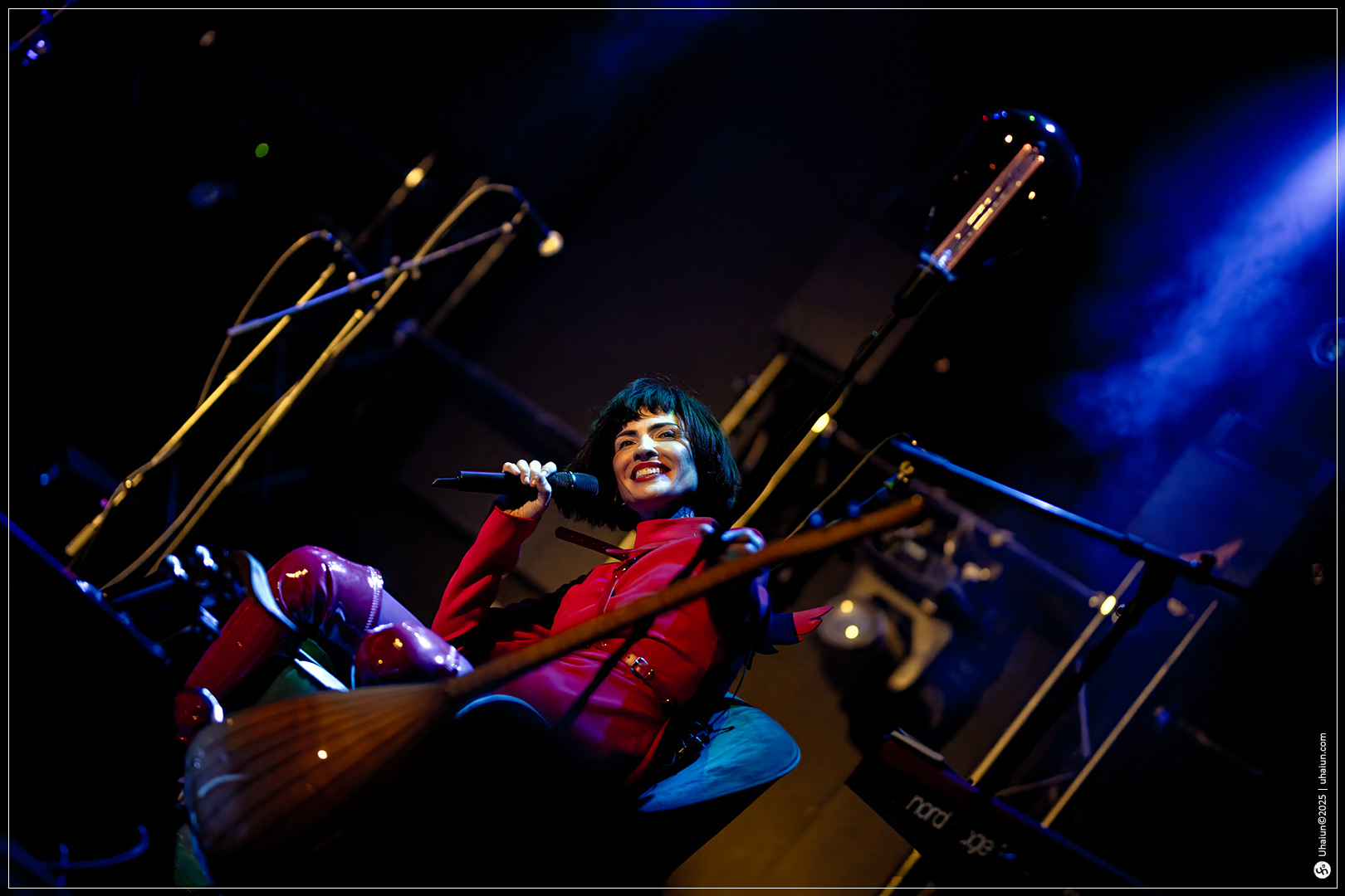 Performer singing on stage in colorful lighting