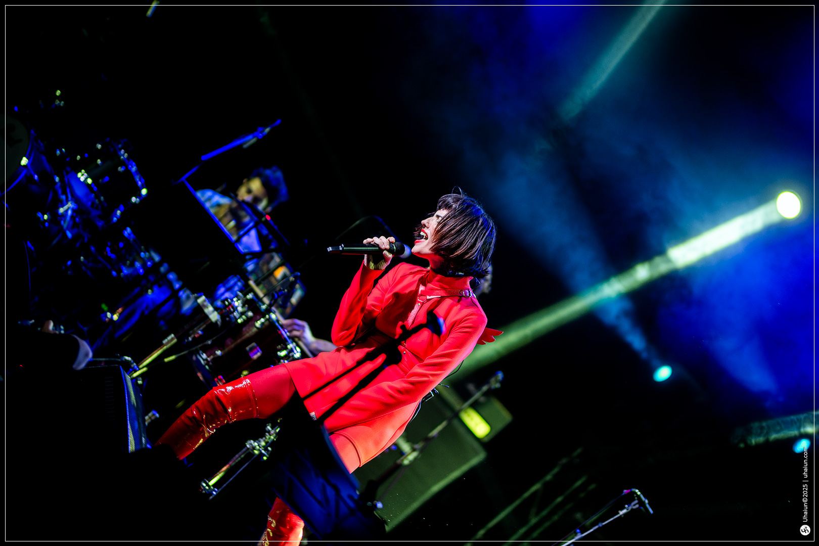 Singer performing live on stage with spotlight