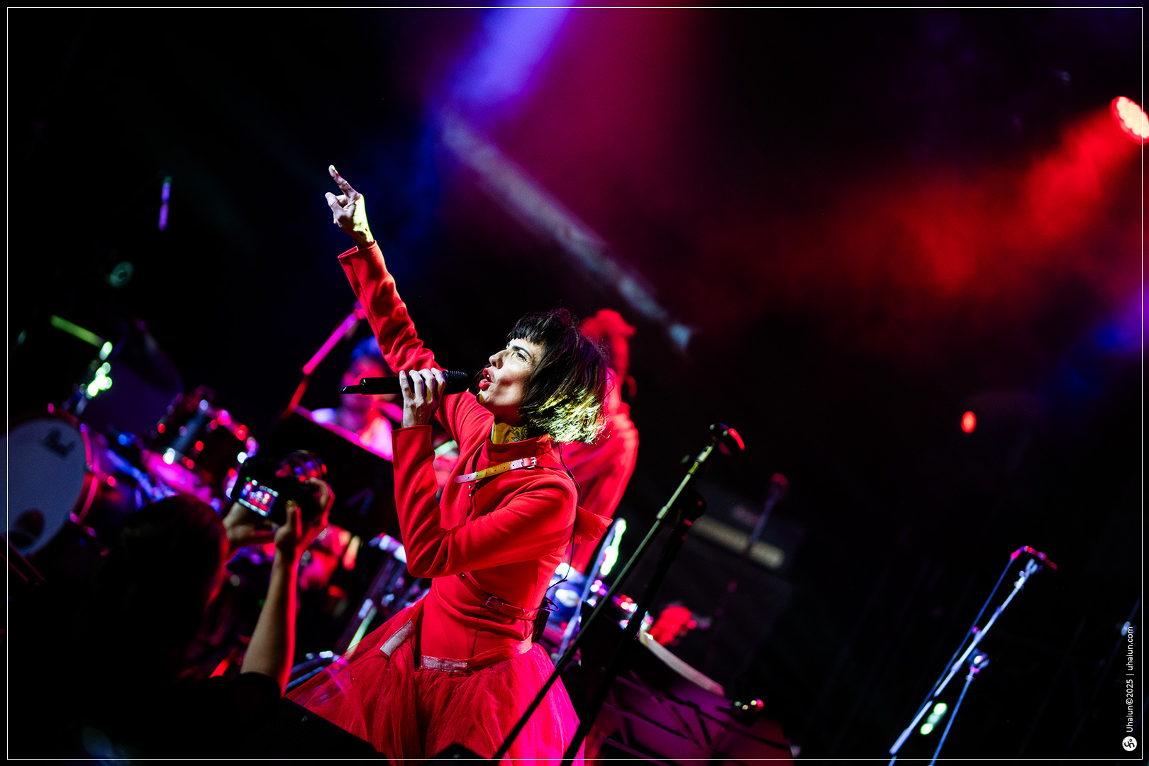Singer performing energetically on stage with lights