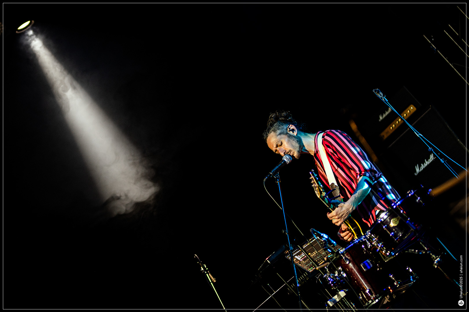 Musician performing live under spotlight on stage