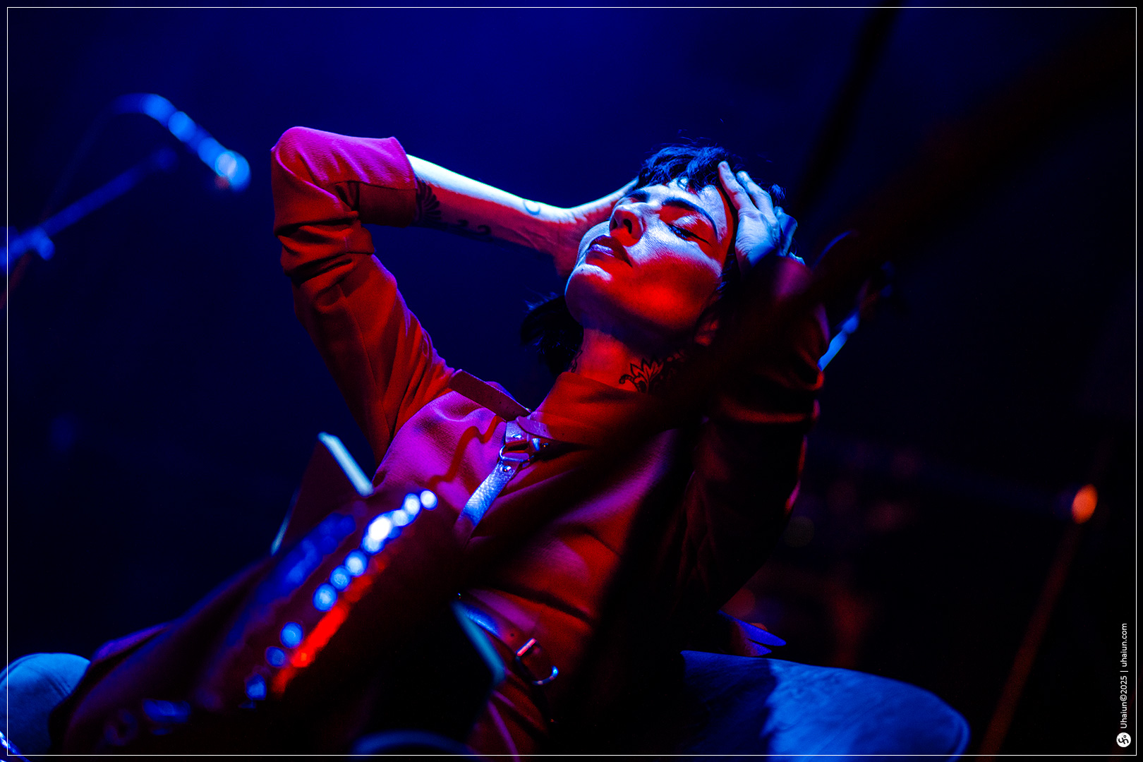Performer on stage in dramatic lighting pose