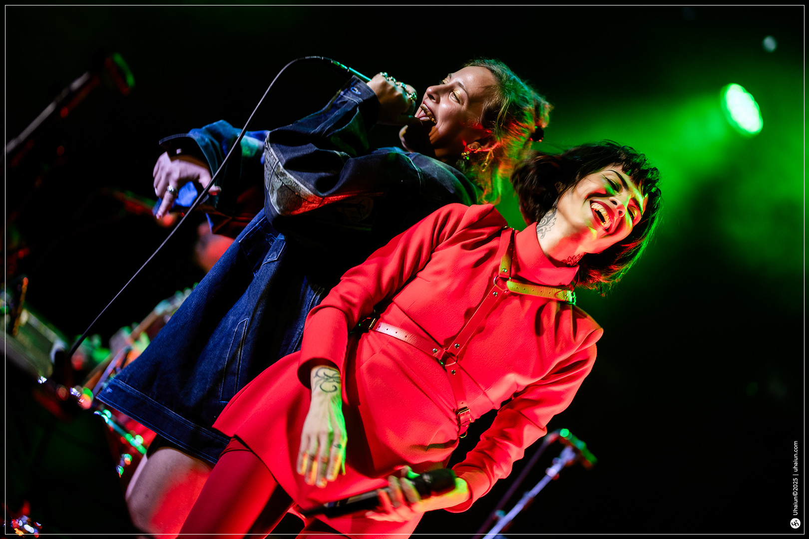 Two singers performing energetically on stage