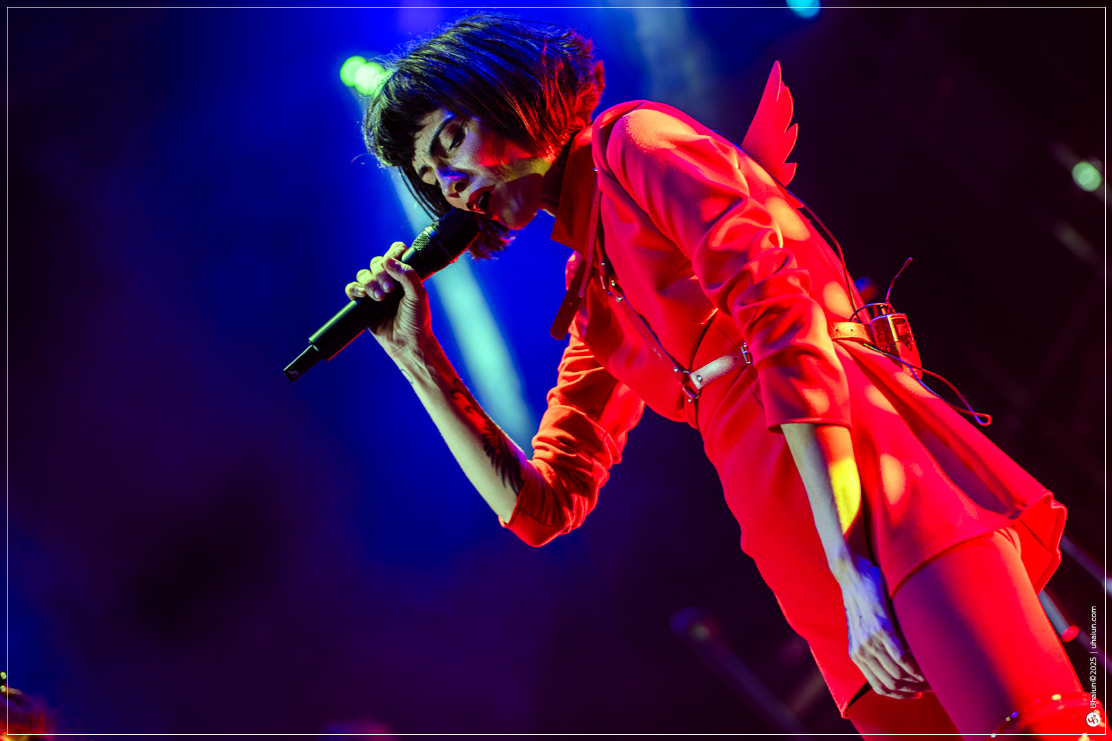 Performer singing energetically on colorful stage