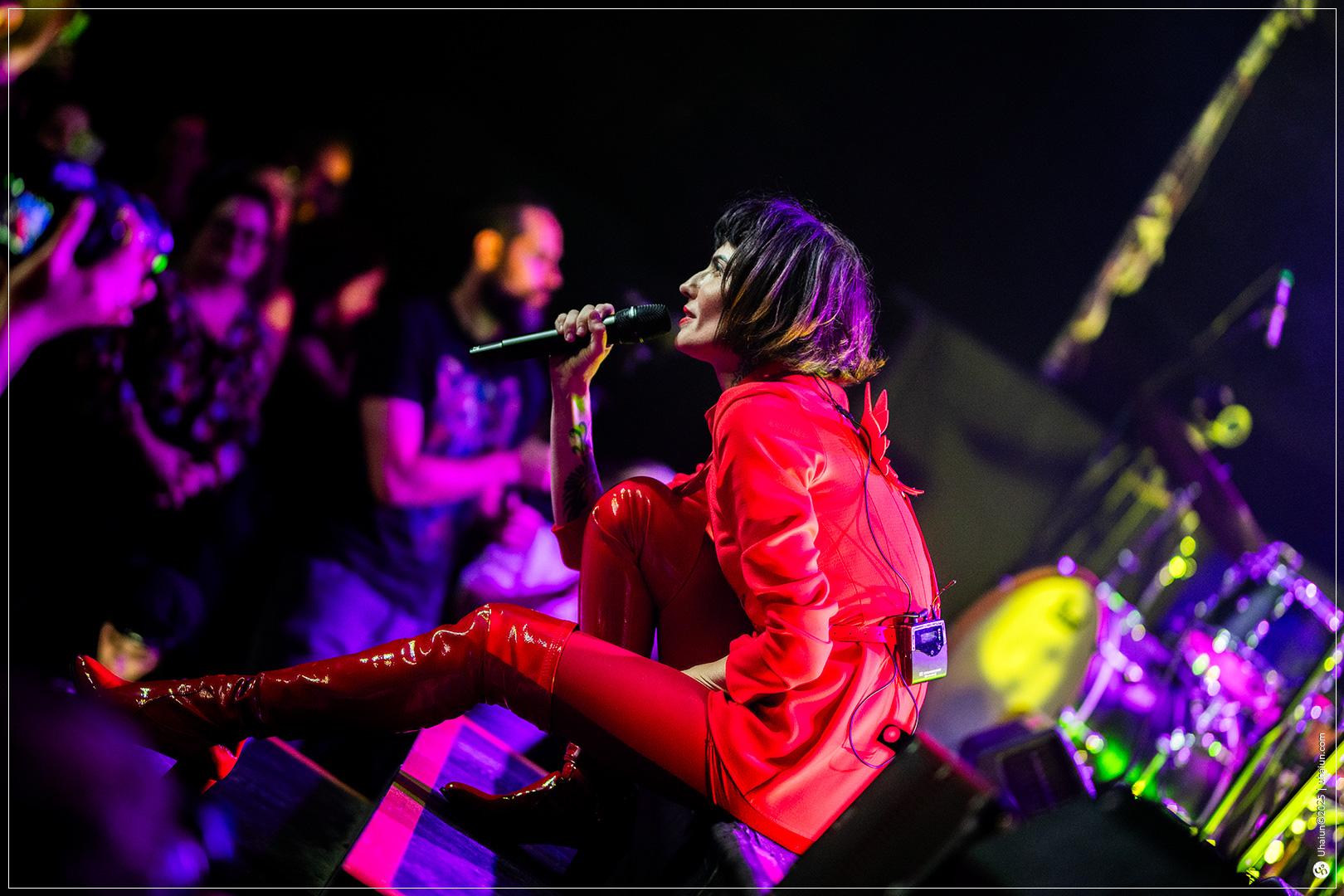 Singer performing live on stage in red