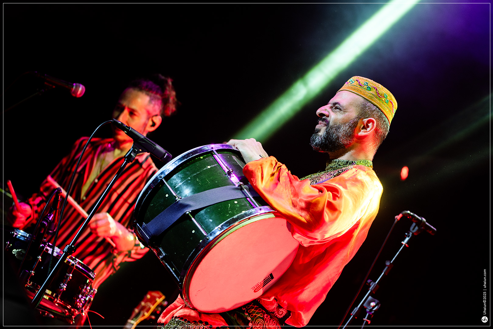 Musicians performing energetically on stage with drums