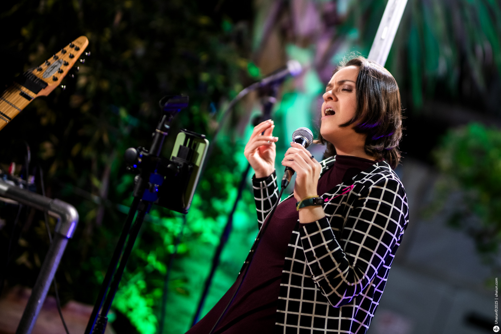 Woman passionately singing on stage during performance