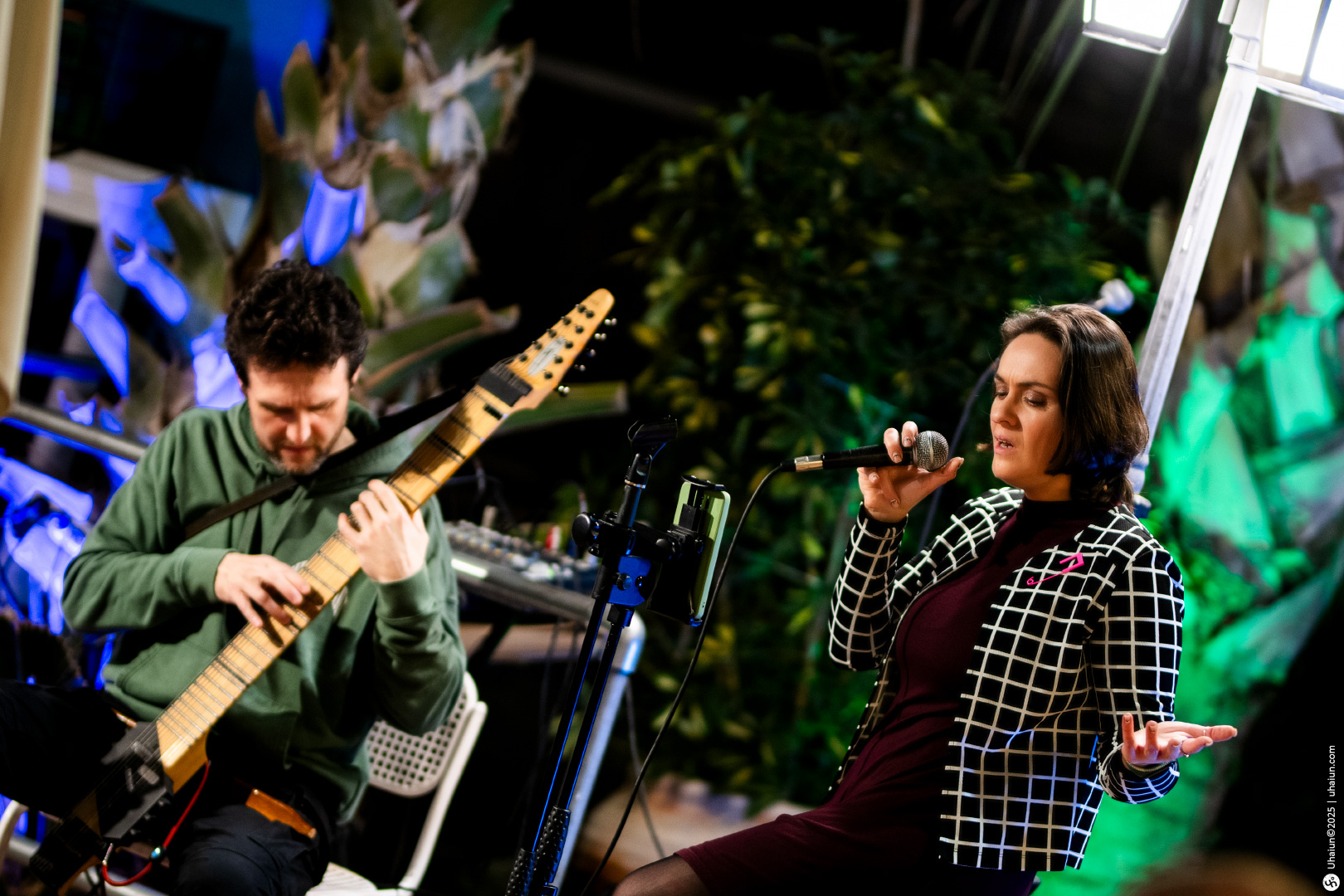 Musician playing guitar and singer performing live