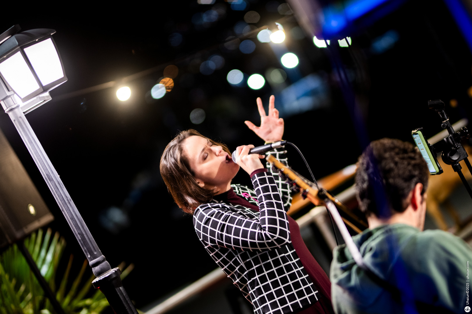 Singer performing passionately under city lights nighttime