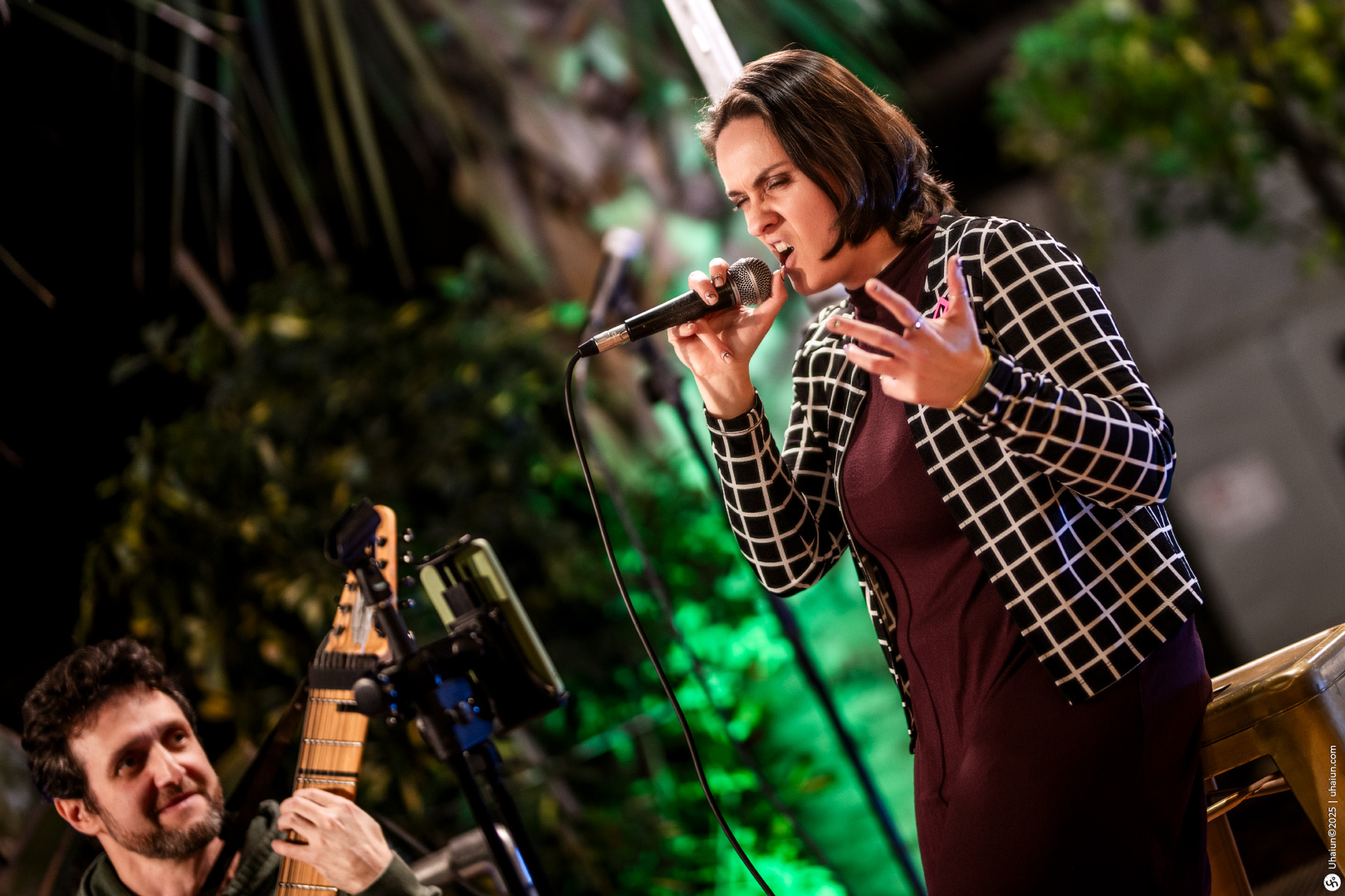 Woman singing passionately outdoor with guitarist accompaniment