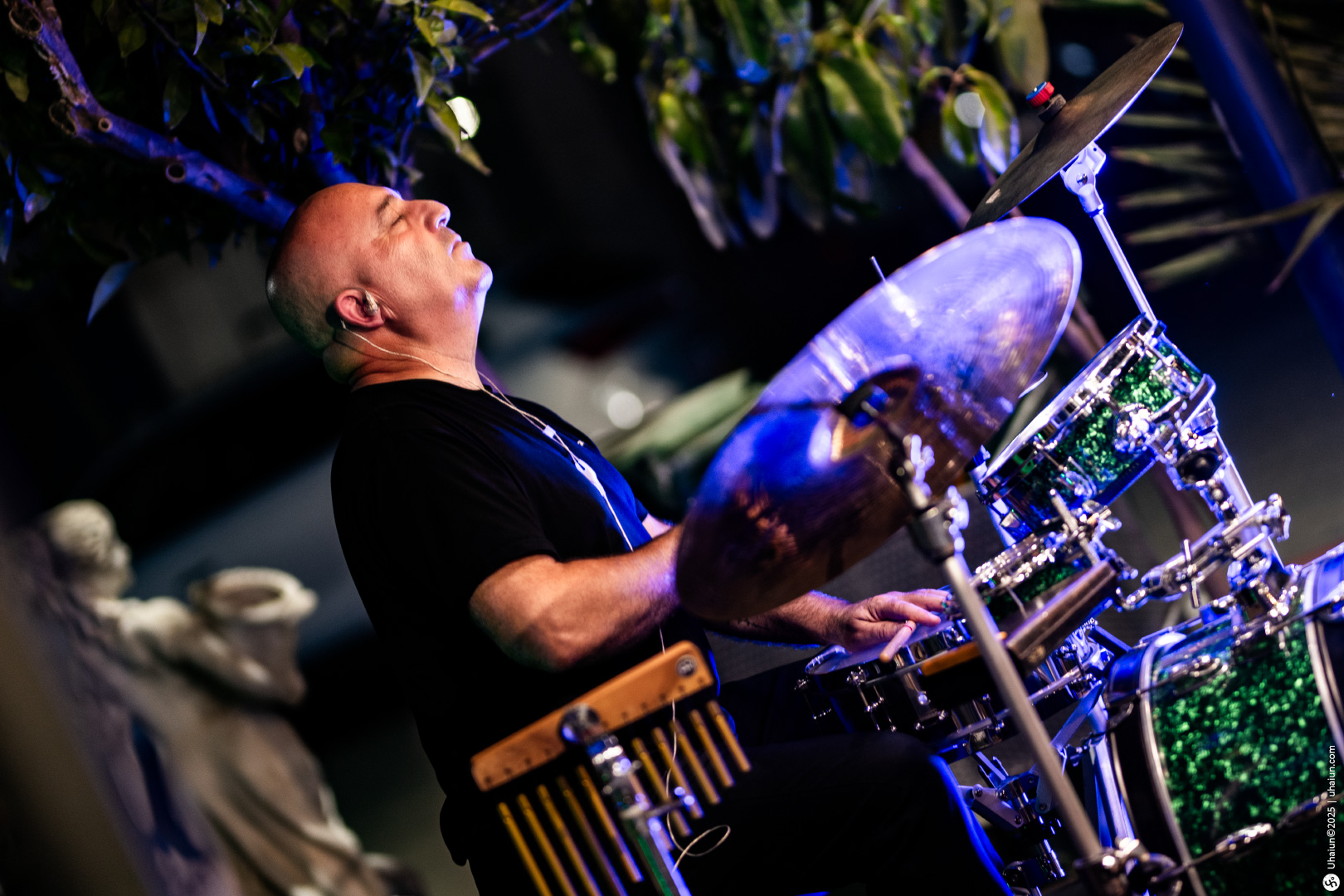 Drummer performing passionately at outdoor night concert