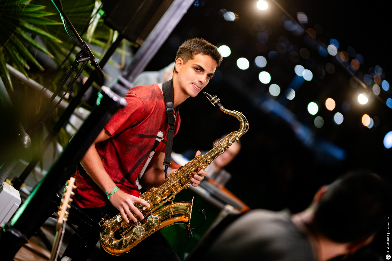 Young musician playing saxophone at night event