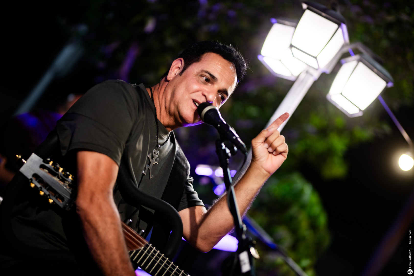Musician performing live with illuminated background scenery
