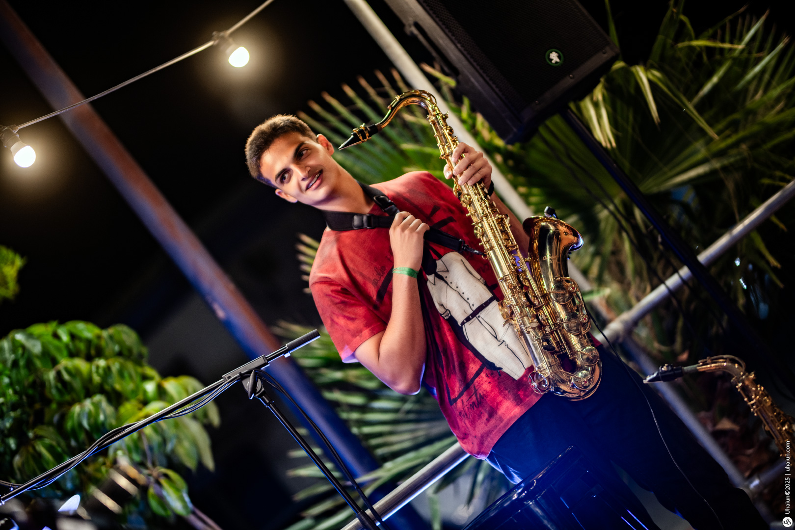 Person playing saxophone at outdoor event night