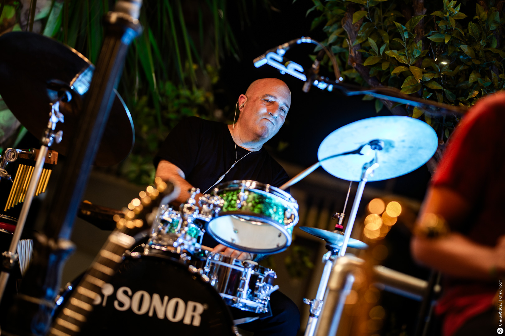 Drummer performing live music outdoors at night