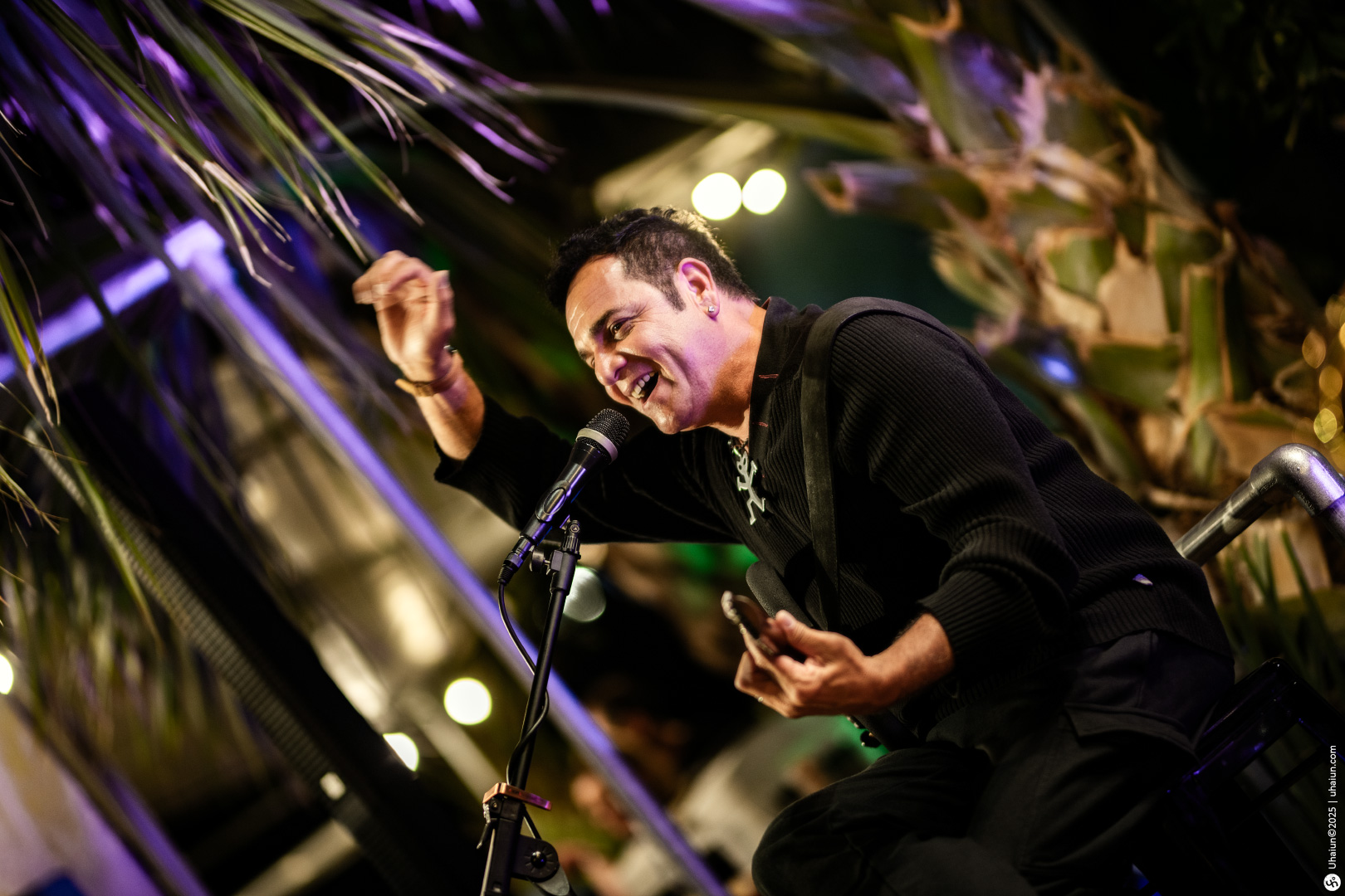 Musician performing passionately on outdoor stage microphone