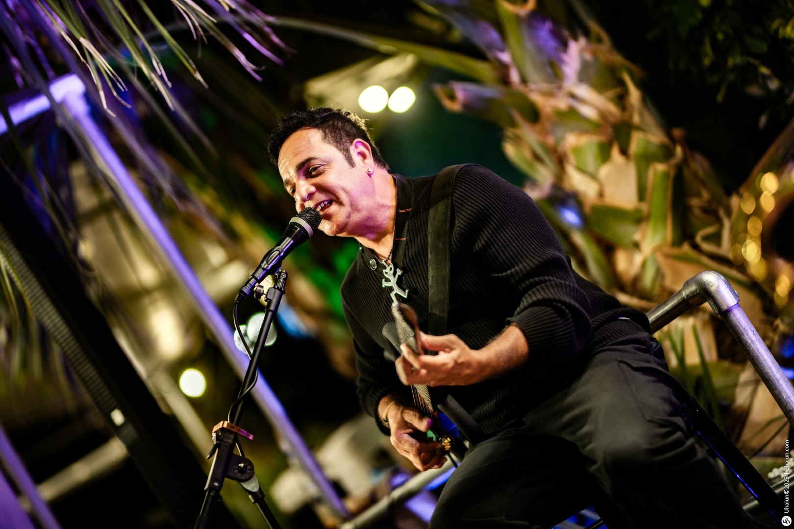 Musician performing live on stage with guitar